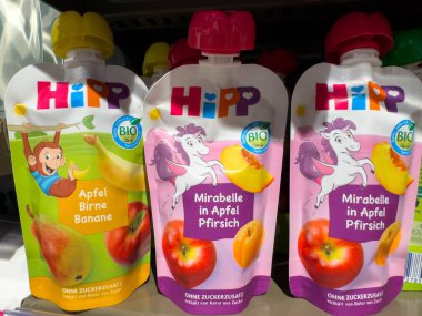 Villach, Avusturya - 15 Ağustos 2025: HiPP 'nin sunduğu organik bebek maması torbaları, elma, armut ve şeftali aromaları, açık renkli bir süpermarket rafında sergileniyor.