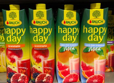Villach, Avusturya - 15 Ağustos 2025: Rauch Happy Day meyve suyu kutuları süpermarket raflarında canlı renkleri ve sağlıklı seçenekleri vurgulayan nar ve pembe greyfurt aromaları sergiliyor