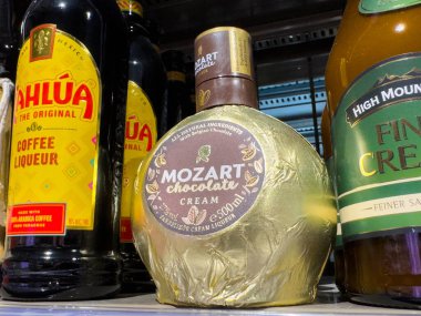 Villach, Avusturya - 15 Ağustos 2025: Mozart Çikolatalı Krema likörü, bir perakende satış rafında diğer likörlerin arasında belirgin bir şekilde sergilenmektedir.