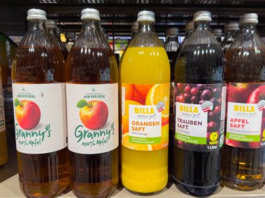 Villach, Avusturya - 15 Ağustos 2025: Süpermarket ortamında Granny 'nin elma suyu, portakal suyu ve üzüm suyu da dahil olmak üzere çeşitli meyve suyu şişelerinin gösterimi
