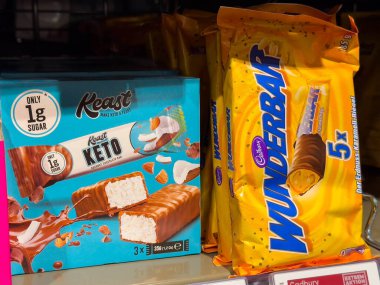 Villach, Avusturya - 15 Ağustos 2025: Keast Keto protein barları ve Cadbury Wunderbar çikolataları açık bir şekilde süpermarket rafında sergileniyor,