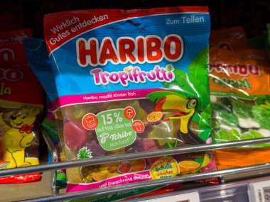 Villach, Avusturya - 15 Ağustos 2025: Haribo Tropifrutti şeker paketi parlak renkler ve eğlenceli grafiklerle dolu bir mağaza rafında sergileniyor