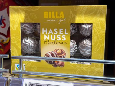 Villach, Avusturya - 15 Ağustos 2025: BILLA Haselnuss Pralinen kutusu perakende rafında fındıklı lezzetli çikolatalı pralinler sergiliyor