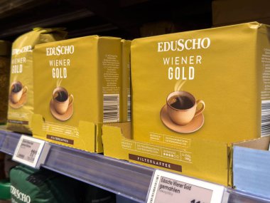 Villach, Avusturya - 15 Ağustos 2025: Eduscho Wiener Gold kahvesi parlak sarı paketleme ve çekici tasarım unsurları içeren bir süpermarket rafında belirgin bir şekilde sergilenmektedir