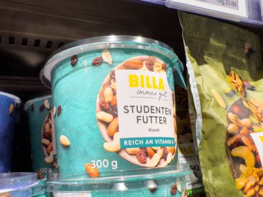 Villach, Avusturya - 15 Ağustos 2025: BILLA Studenten Futter konteynırı süpermarket rafında renkli ambalajlar ve sağlıklı fındık ve kurutulmuş meyve karışımlarıyla sergilenmektedir.