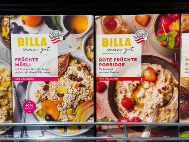 Villach, Avusturya - 15 Ağustos 2025: BILLA meyveli müsli ve kırmızı meyveli lapa paketleme süpermarket rafında, cazip tasarımlarla besleyici kahvaltı seçeneklerini vurguluyor