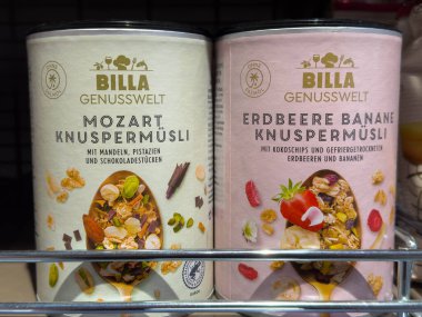 Villach, Avusturya - 15 Ağustos 2025: BILLA Genusswelt atıştırmalık konteynerleri Mozart ve Erdbeere Banane Knuspermusli 'yi canlı malzemeler ve çekici ambalajlarla sergiliyor