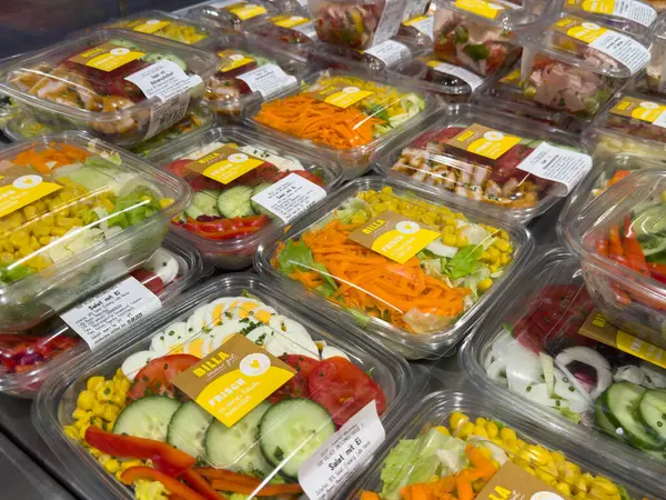 Villach, Avusturya - 15 Ağustos 2025: Etiketli şeffaf kaplarda taze salatalar, sağlıklı yemek ve yemek hazırlamak için mükemmel