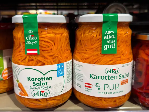 Villach, Avusturya - 15 Ağustos 2025: Elko havuç salatası kavanozları açık bir şekilde bir süpermarket rafında sergileniyor, canlı turuncu renkleri ve sağlıklı cazibeleri vurgulanıyor