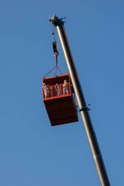 Faak Am See, Avusturya - 09 Ağustos 2025: Kırmızı vinç üç kişilik bir platformu yükselterek, 1.4.