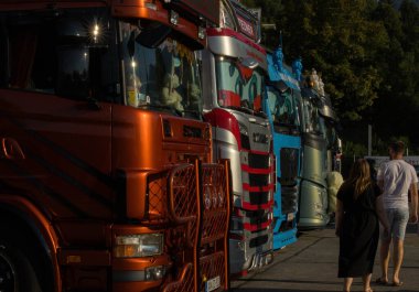 Faak Am See, Avusturya - 09 Ağustos 2025: Motion Teddy Bear 1.4 sırasında Faak Gölü 'nde sıralanmış renkli kamyonlar, kamyoncuların neşesini ve birliğini vurguluyor