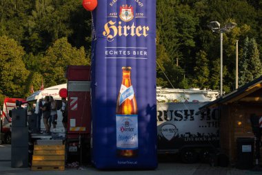 Faak Am See, Avusturya - 09 Ağustos 2025: Şişirilebilir Hirter bira afişi Motion Teddy Bear 1.4 sırasında Faak Gölü 'nde sergilenerek canlı olay atmosferini artırdı