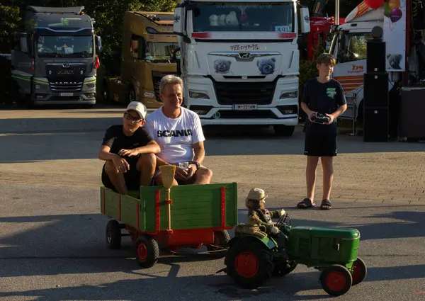 Faak Am See, Avusturya - 09 Ağustos 2025: Motion Teddy Bear 1.4 sırasında Faak Gölü 'nde kalbi olan kamyoncular, renkli çevreye sahip oyuncak traktörle çocukları gösteriyorlar.