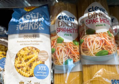 Villach, Avusturya - 18 Ağustos 2025: Rafta düşük karbonhidratlı makarna ürünleri sergilenirken, Dralli ve Zeki Dinkel Spaghetti çekici ambalaj tasarımı sergileniyor