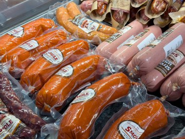 Villach, Avusturya - 18 Ağustos 2025: Markette paketlenmiş sosislerin rengarenk gösterimi, farklı lezzet ve dokuların aşçılık kullanımı için vurgulanması