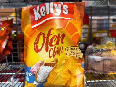 Villach, Avusturya - 18 Ağustos 2025: Kelly 'nin Ofen Chips çantası, rengarenk tasarımı ve çekici abur cubur seçeneklerini ön plana çıkaran bir market rafında yer alıyor