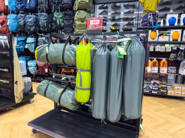 Villach, Avusturya - 18 Ağustos 2025: Bir perakende mağazasında kamp vitrinleri ve uyku tulumları sergileniyor, hevesliler için açık hava macera gerekliliklerini vurguluyor