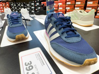 Villach, Avusturya - 18 Ağustos 2025: Adidas spor ayakkabıları, şık tasarımları ve canlı renkleri ön plana çıkarak perakende satış mağazasında sergilenmektedir