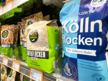 Villach, Avusturya - 18 Ağustos 2025: Hoch Genuss yulaf ezmesi ve Kolln taneleri belirgin bir şekilde süpermarket rafında sergilenmekte, besleyici kahvaltı seçeneklerini vurguluyorlar