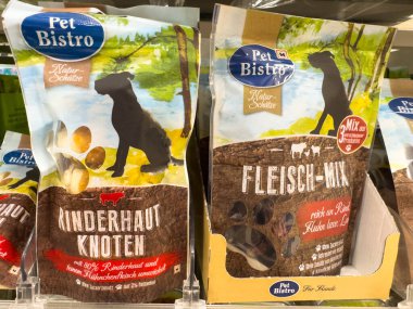 Villach, Avusturya - 18 Ağustos 2025: Raftaki Pet Bistro köpek maması paketleri, Rinderhaut Knoten ve Fleisch-Mix 'i canlı renklerle ve doğal betimlemelerle vurguluyor
