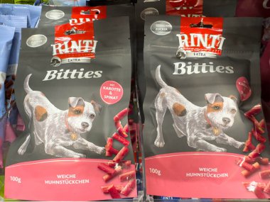 Villach, Avusturya - 18 Ağustos 2025: RINTI Bitties köpek maması ambalajları neşeli bir köpek illüstrasyonu sergiliyor, kaliteli malzemelerin vurgulanması ve hayvan sahipleri için çekici tasarım