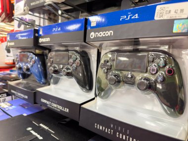 Villach, Avusturya - 18 Ağustos 2025: Nacon PS4 kompakt denetleyicileri, oyuncular için tasarımlarını ve canlı renklerini vurgulayan bir perakende rafta düzgün bir şekilde düzenlenmiştir