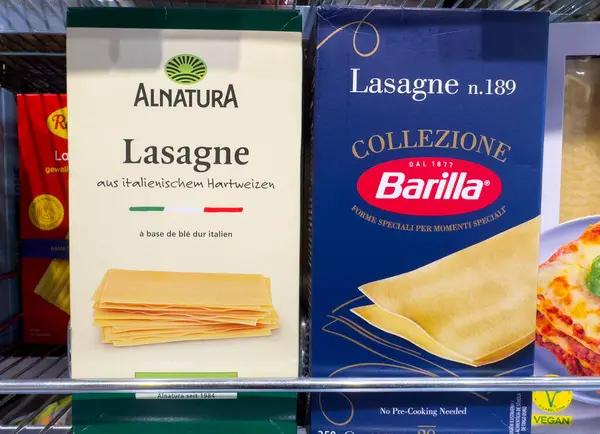 Villach, Avusturya - 18 Ağustos 2025: Alnatura ve Barilla lazanya kutuları belirgin bir şekilde bir rafta sergilenmekte, farklı ambalajlarını ve İtalyan mirasını kopyalama alanı ile işaretlemektedirler.