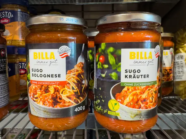 Villach, Avusturya - 18 Ağustos 2025: BILLA makarna sosları Sugo Bolognese ve Sugo Krauter süpermarket raflarında renklendirici etiketler ve cazip gıda seçenekleri ile renklendiriliyor