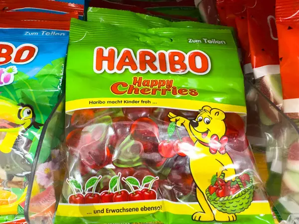 Villach, Avusturya - 18 Ağustos 2025: Haribo Happy Cherries şeker çantası neşeli bir ayıyla canlı jelibon şekerlemeleri sergiliyor, festival vesilesi ve arkadaşlarla paylaşmak için ideal