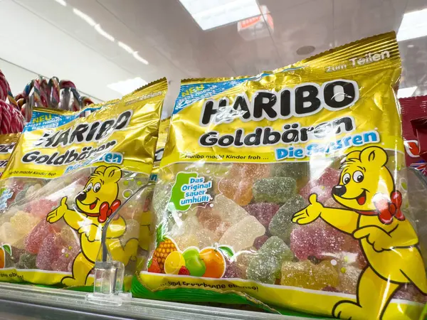 Villach, Avusturya - 18 Ağustos 2025: Haribo Goldbaren jelibon ayıları, renkli ambalajlarını ve lezzetli şeker çeşitlerini ön plana çıkaran bir mağaza rafında sergilenmektedir.