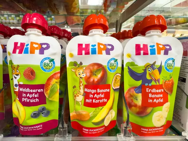Villach, Avusturya - 18 Ağustos 2025: HiPP organik bebek maması kesesi süpermarket raflarında çeşitli meyve aromaları sergiliyor, renkli ambalajlar ve sağlıklı seçenekler vurgulanıyor