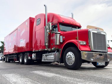 Klagenfurt, Avusturya - 20 Ağustos 2025: Kırmızı Coca-Cola kamyonu şehir sokağına park edilmiş, belirgin markasını ve canlı tasarımını vurguluyor