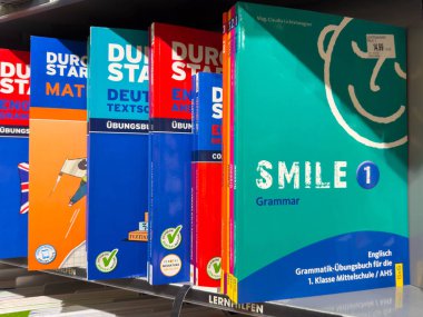 Klagenfurt, Avusturya - 20 Ağustos 2025: Gramer ve dil eğitimi gibi renkli kapaklar ve konuların yer aldığı eğitim kitapları bir rafta sergileniyor