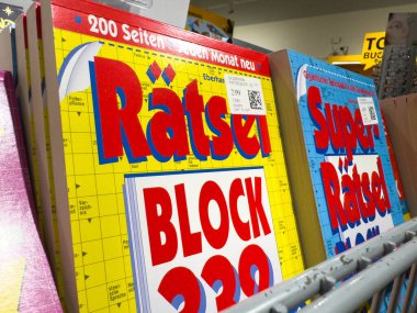 Klagenfurt, Avusturya - 20 Ağustos 2025: Renkli bulmaca dergileri bir kitapçıdaki rafta düzenlenmiştir.