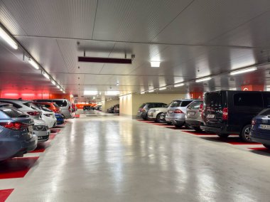 Villach, Avusturya - 21 Ağustos 2025: Yeraltı otoparkında çok sayıda park edilmiş araç, geniş ve organize tasarım