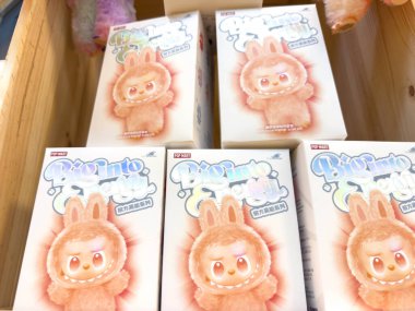 Villach, Avusturya - 21 Ağustos 2025: Çizgi film tavşan peluş oyuncak paketleri parlak renkler ve çocuklar için kaprisli bir tasarım içeren ahşap bir kutuda düzenlenmiştir.