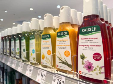 Villach, Avusturya - 21 Ağustos 2025: Rausch şampuan şişeleri etkin saç bakımı çözümleri için renkli ambalajlar ve doğal malzemeler içeren raflarda düzenlendi