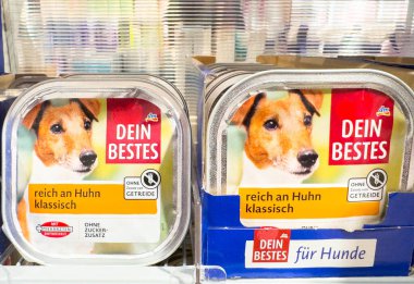 Villach, Avusturya - 21 Ağustos 2025: DEIN BESTES köpek maması ambalajında renkli bir süpermarket koridorunda klasik tavuk aromalı neşeli bir köpek sergileniyor
