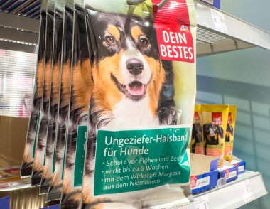 Villach, Avusturya - 21 Ağustos 2025: Köpek pire tasması ambalajı, mutlu bir köpek ve evcil hayvan bakımı için temel ürün detaylarını gösteren bir rafta sergileniyor