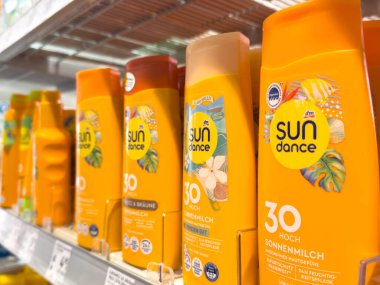 Villach, Avusturya - 21 Ağustos 2025: Güneş Dansı güneş kremi ürünleri etkin cilt bakımı için parlak renkler ve güneş koruma bilgileri içeren mağaza raflarında düzenlendi