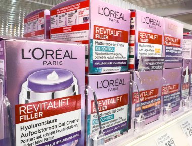 Villach, Avusturya - 21 Ağustos 2025: L 'Oreal Paris Revitalift Doldurucu cilt ürünleri, canlı ambalaj ve güzellik cazibesini vurgulayarak perakende bir rafta düzgünce düzenlenmiştir