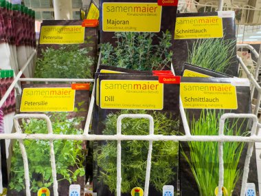 Villach, Avusturya - 21 Ağustos 2025: Dereotlu, maydanozlu ve soğanlı bitki tohumu paketleri, bahçıvanlık aşıkları için mükemmel bir şekilde bir mağazada düzenlenmiştir.