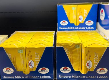 Villach, Avusturya - 21 Ağustos 2025: Süpermarket raflarında sergilenen Kerrygold tereyağı paketleri, canlı sarı renkler ve çekici ambalaj tasarımı