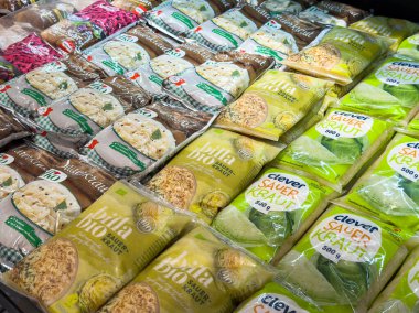 Villach, Avusturya - 21 Ağustos 2025: Markette paketli lahana turşusu ve eriştenin canlı çeşitleri, çeşitli markalar ve renkli tasarımlar vurgulanıyor