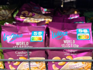 Villach, Avusturya - 21 Ağustos 2025: Lorenz fındık paketleri belirgin bir şekilde süpermarket rafında sergileniyor, canlı renkler ve sağlıklı atıştırmalık seçenekleri vurgulanıyor