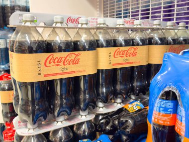 Villach, Avusturya - 21 Ağustos 2025: Bir marketteki rafta sergilenen Coca-Cola hafif şişeleri, içecek ambalajı ve marka cazibesini vurguluyor