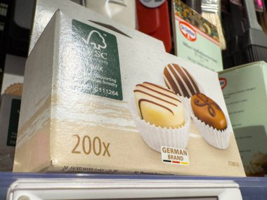 Villach, Avusturya - 21 Ağustos 2025: Bir fırın rafında üç çikolatayla kaplanmış tatlı lezzetleri ön plana çıkaran Alman hamur işleri