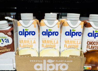 Villach, Avusturya - 21 Ağustos 2025: Alpro vanilya ve çikolata aromalı bitkisel içecekler, çekici ambalajlarını vurgulayarak, perakende satış rafında güzelce düzenlenir