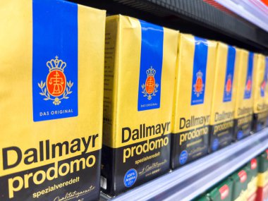 Villach, Avusturya - 21 Ağustos 2025: Dallmayr Prodomo kahve kutuları, markanın ayırt edici sarı ambalajı ve kalitesini ön plana çıkaran bir süpermarket rafına güzelce yerleştirilmiştir.