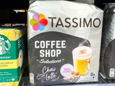 Villach, Avusturya - 21 Ağustos 2025: Tassimo Chai Latte ambalajı belirgin bir şekilde bir süpermarket rafında sergileniyor, renkli tasarımını ve çekici kahve seçimini ön plana çıkarıyor